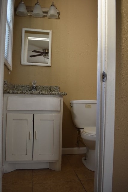 bathroom with tile patterned flooring, vanity, and toilet