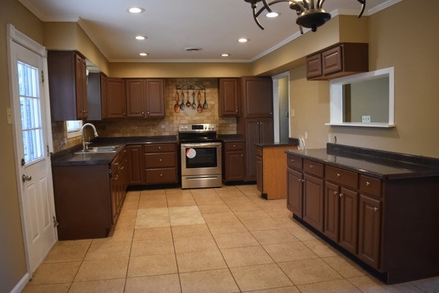 kitchen featuring stainless steel range with electric cooktop, light tile patterned floors, crown molding, and sink