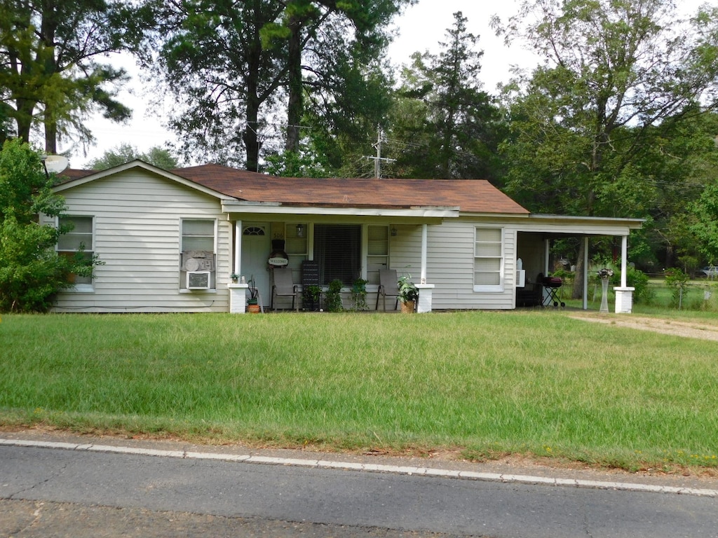 view of front of property featuring cooling unit, a front lawn, and covered porch