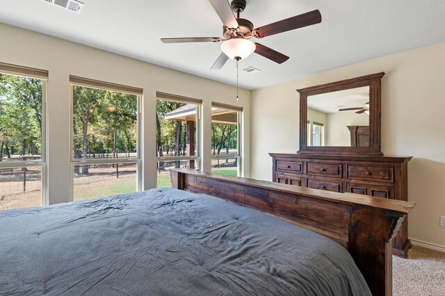 bedroom with ceiling fan, light colored carpet, and a closet