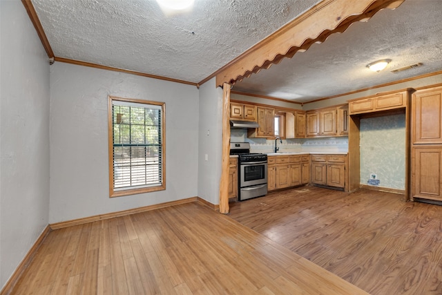 kitchen with a textured ceiling, light hardwood / wood-style floors, sink, and stainless steel gas range oven