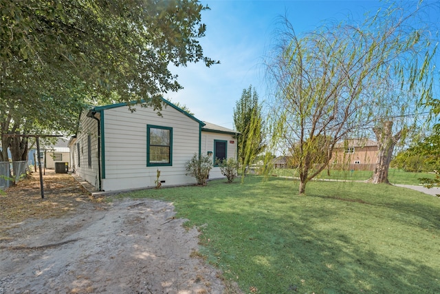 view of front of property with central AC unit and a front lawn