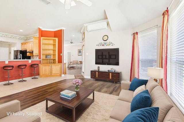 living room featuring wood finished floors, a ceiling fan, an AC wall unit, and ornamental molding