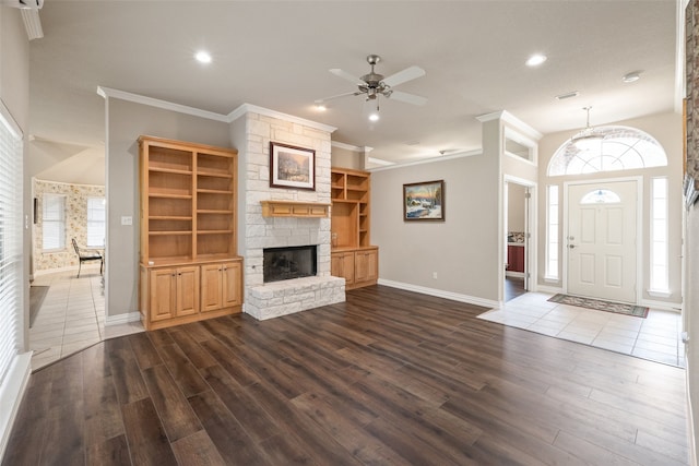 unfurnished living room featuring a fireplace, crown molding, hardwood / wood-style floors, and ceiling fan