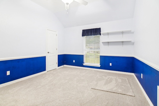 empty room with lofted ceiling, baseboards, carpet floors, and ceiling fan