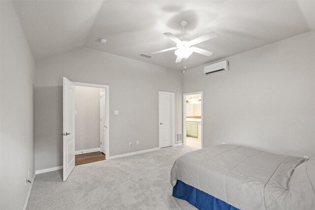 carpeted bedroom featuring ceiling fan, vaulted ceiling, connected bathroom, and a wall mounted AC