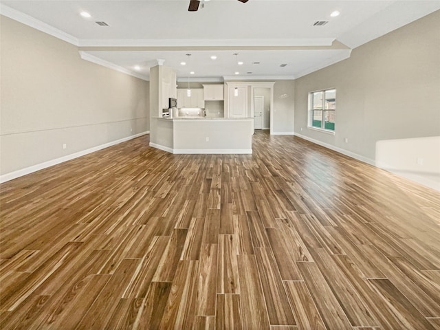 unfurnished living room with ceiling fan, hardwood / wood-style flooring, and ornamental molding