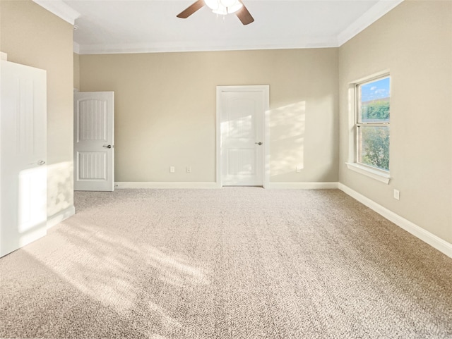 empty room with carpet flooring, ceiling fan, and ornamental molding