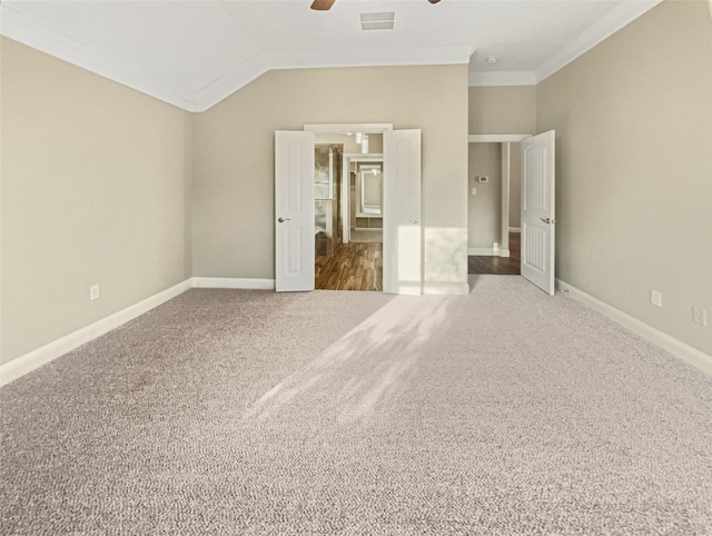 unfurnished bedroom featuring lofted ceiling, carpet flooring, ceiling fan, and crown molding