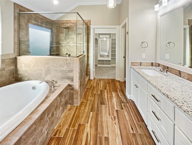 bathroom with vanity, ornamental molding, independent shower and bath, and hardwood / wood-style flooring