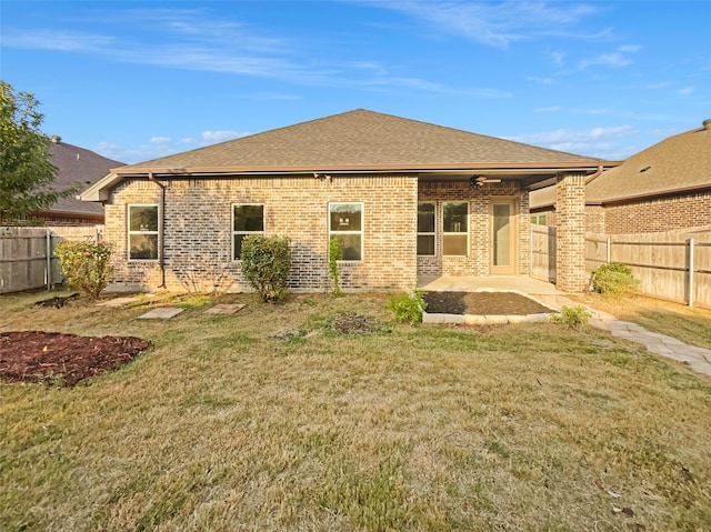 back of property with a yard and a patio