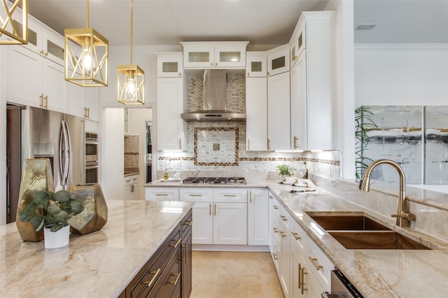 kitchen with light stone countertops, sink, wall chimney exhaust hood, pendant lighting, and white cabinets