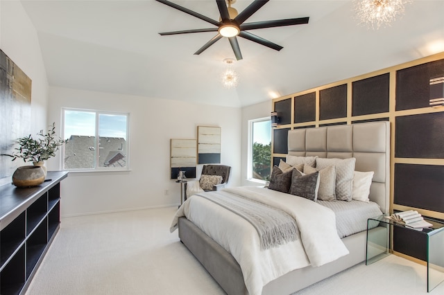 carpeted bedroom with multiple windows, ceiling fan with notable chandelier, and lofted ceiling