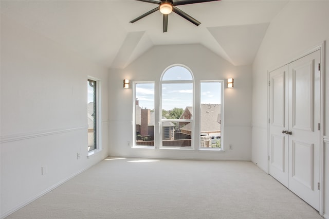 interior space with a wealth of natural light, ceiling fan, and vaulted ceiling