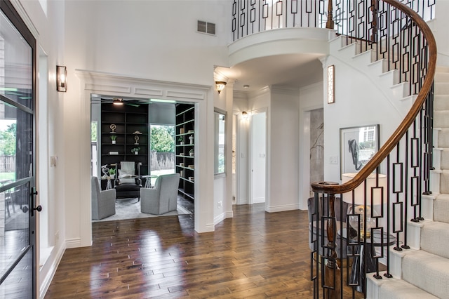 foyer entrance with a high ceiling, dark hardwood / wood-style flooring, and crown molding