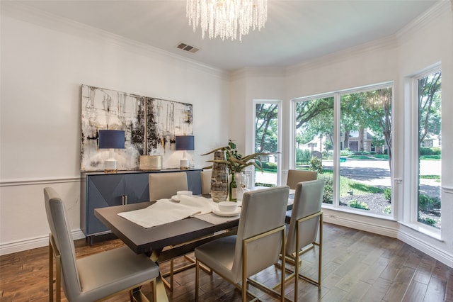 dining area with crown molding, dark wood-type flooring, a healthy amount of sunlight, and an inviting chandelier