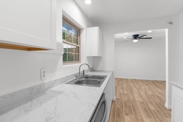 kitchen with light wood-type flooring, ceiling fan, white cabinetry, and sink