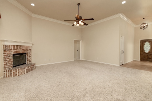 unfurnished living room featuring a fireplace, crown molding, a towering ceiling, and ceiling fan