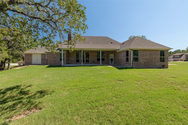 rear view of property with a lawn and a patio area