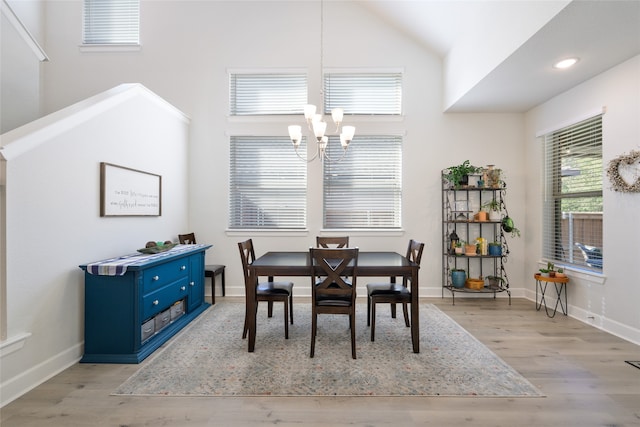 dining space featuring lofted ceiling, a chandelier, and light hardwood / wood-style floors