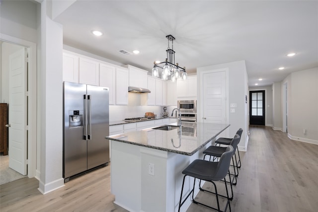 kitchen featuring a center island with sink, stainless steel appliances, white cabinets, and light hardwood / wood-style floors