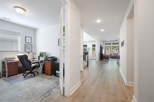 office with light wood-type flooring and ceiling fan