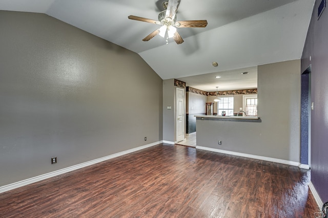 unfurnished living room with vaulted ceiling, ceiling fan, and dark wood-type flooring