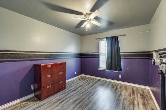 interior space featuring wood-type flooring, ceiling fan, and a textured ceiling