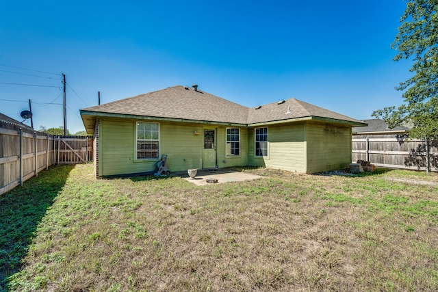 rear view of property featuring a lawn and a patio area