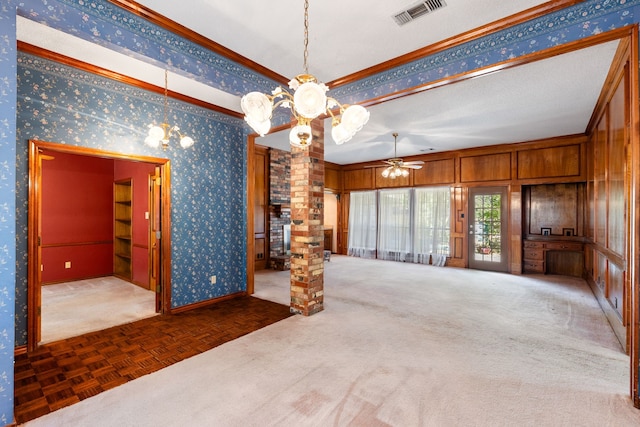 spare room with dark parquet floors, ceiling fan with notable chandelier, wooden walls, and ornamental molding