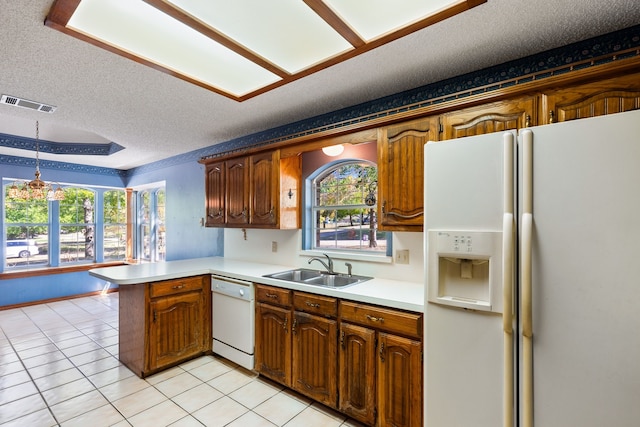 kitchen featuring white appliances, a wealth of natural light, kitchen peninsula, and a textured ceiling