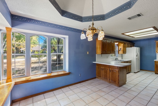 kitchen featuring an inviting chandelier, light tile patterned floors, kitchen peninsula, sink, and a wealth of natural light