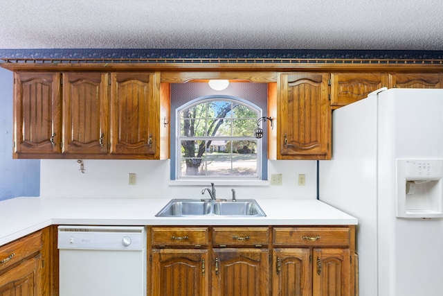 kitchen with white appliances, a textured ceiling, and sink