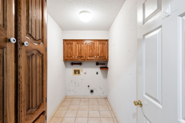 laundry room with cabinets, electric dryer hookup, hookup for a washing machine, a textured ceiling, and light tile patterned floors