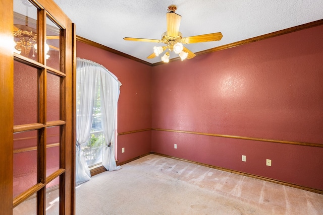 carpeted spare room with crown molding, a textured ceiling, and ceiling fan