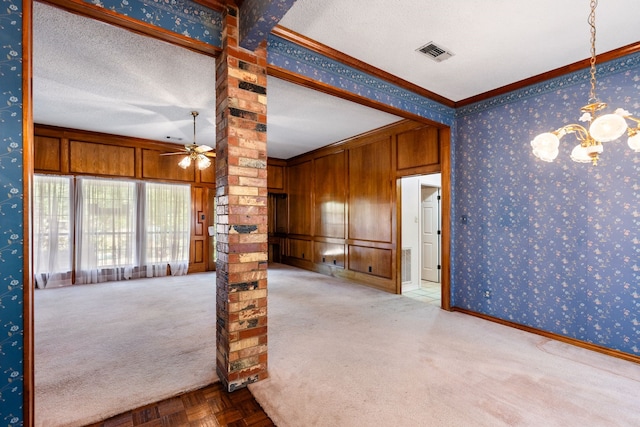 interior space featuring ceiling fan with notable chandelier, light carpet, ornamental molding, and a textured ceiling