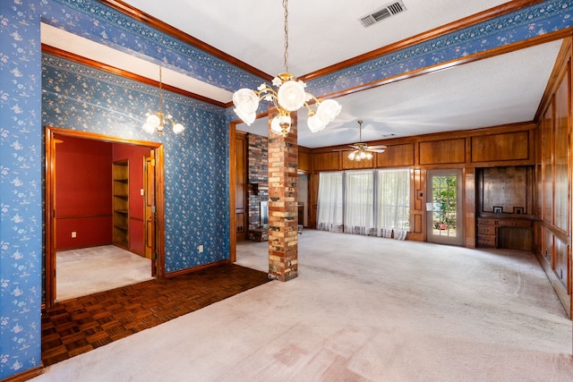 interior space with wooden walls, ceiling fan with notable chandelier, crown molding, a textured ceiling, and dark parquet flooring