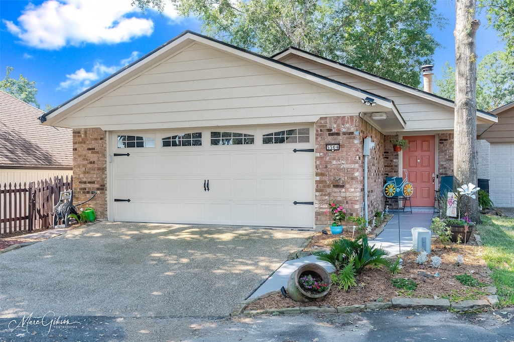 single story home with fence, driveway, a garage, and brick siding