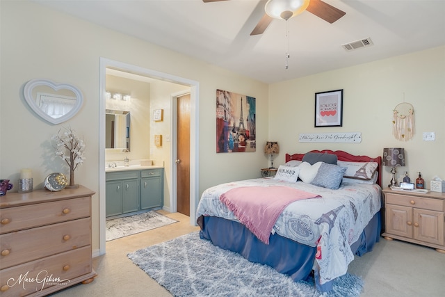 carpeted bedroom featuring ceiling fan and ensuite bath