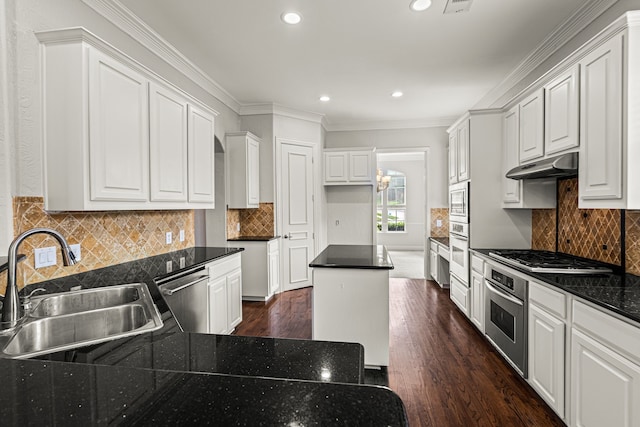 kitchen featuring white cabinets, crown molding, stainless steel appliances, dark hardwood / wood-style flooring, and sink