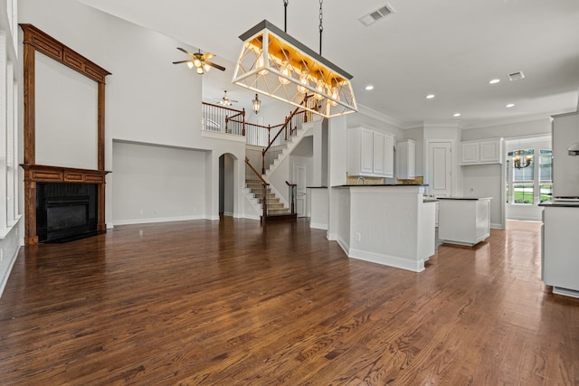 kitchen featuring crown molding, dark hardwood / wood-style flooring, white cabinetry, ceiling fan, and pendant lighting