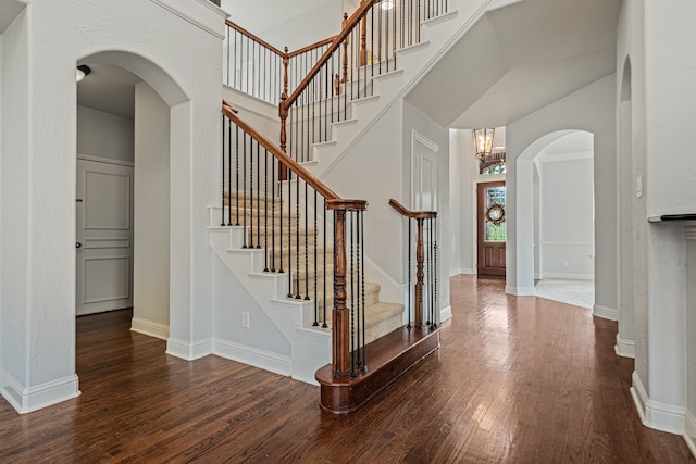 stairs featuring hardwood / wood-style floors and an inviting chandelier