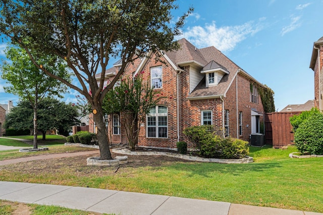 view of front of house with cooling unit and a front lawn