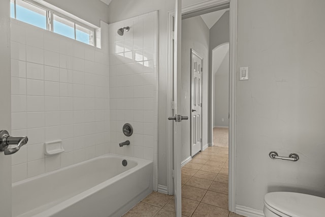 bathroom featuring toilet, tile patterned floors, and tiled shower / bath