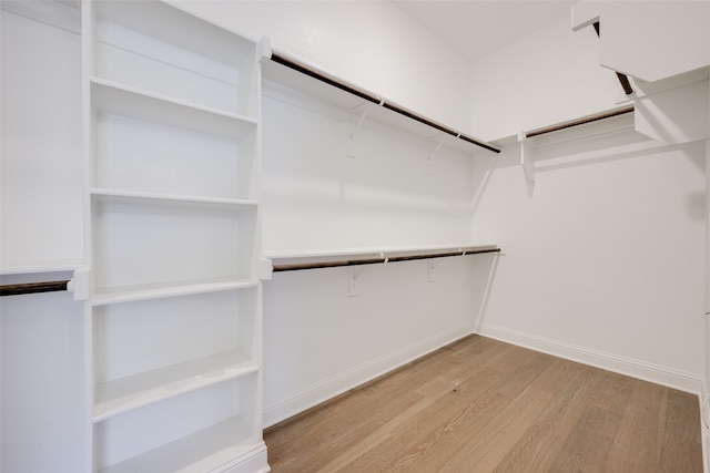 walk in closet with light hardwood / wood-style floors