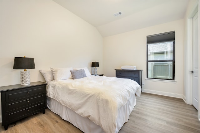 bedroom with light hardwood / wood-style floors and vaulted ceiling