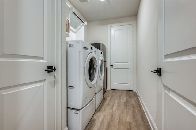 laundry room with independent washer and dryer and light hardwood / wood-style floors