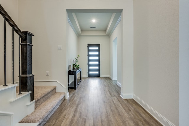 foyer featuring hardwood / wood-style flooring and a tray ceiling