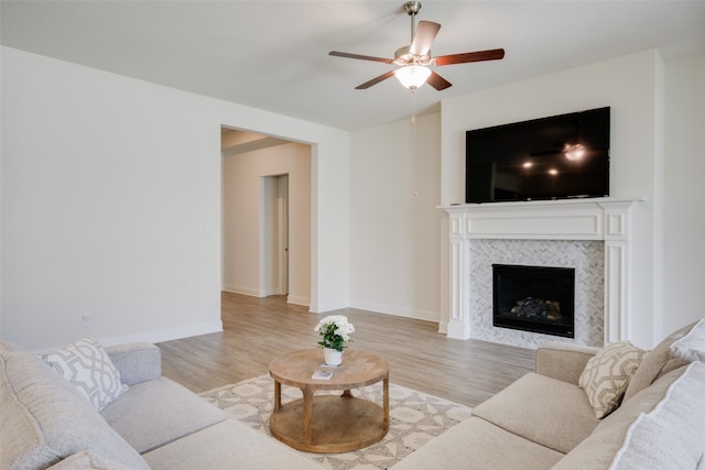 living room featuring ceiling fan and light hardwood / wood-style flooring