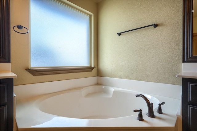 bathroom with a tub to relax in and vanity